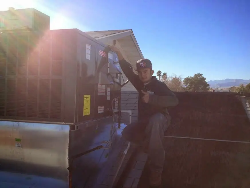 HVAC technician performing Air Duct Repair on a rooftop unit in Ringwood
